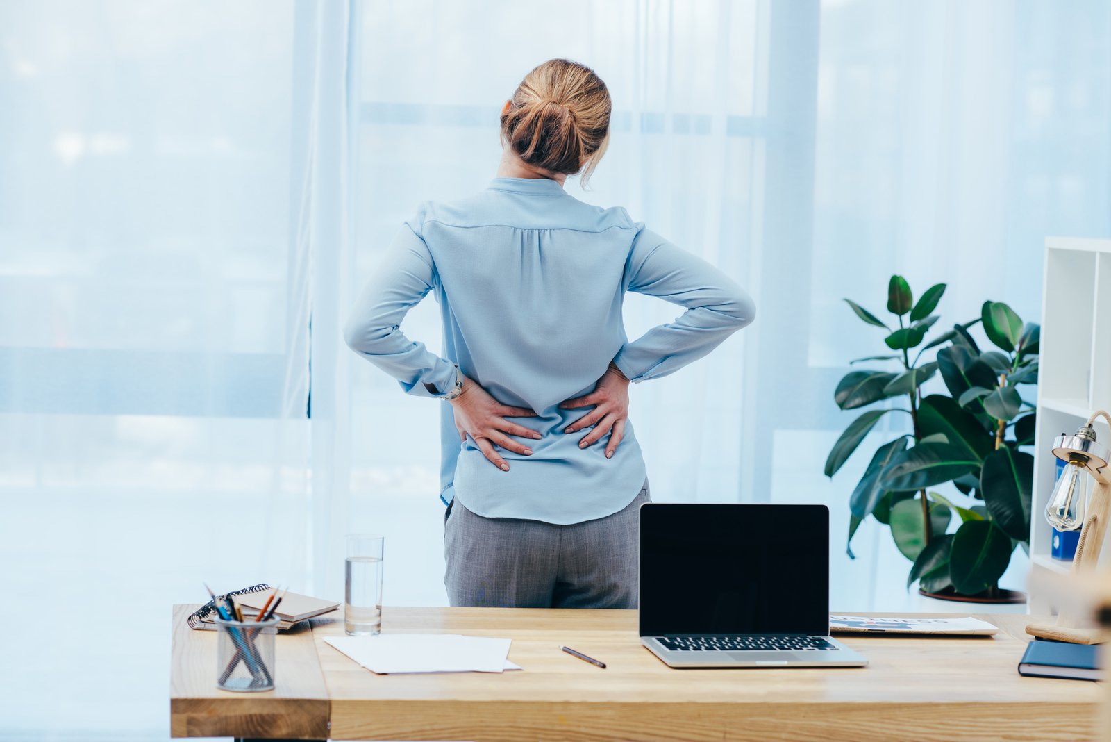 rear view of businesswoman with backplain in office Pain Management Approaches for Better Quality of Life